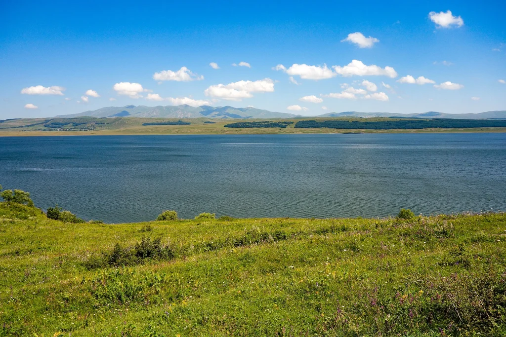 The broad blue expanse of Tsalka Reservoir stretches beneath Mount Arjevani.