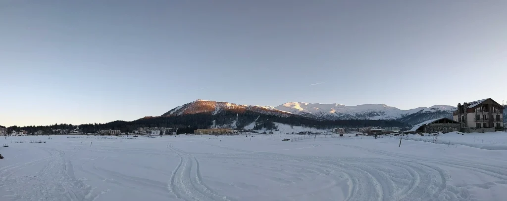 Sunset view of Mount Kokhta, the main ski area of the Bakuriani resort, over snowy plains.