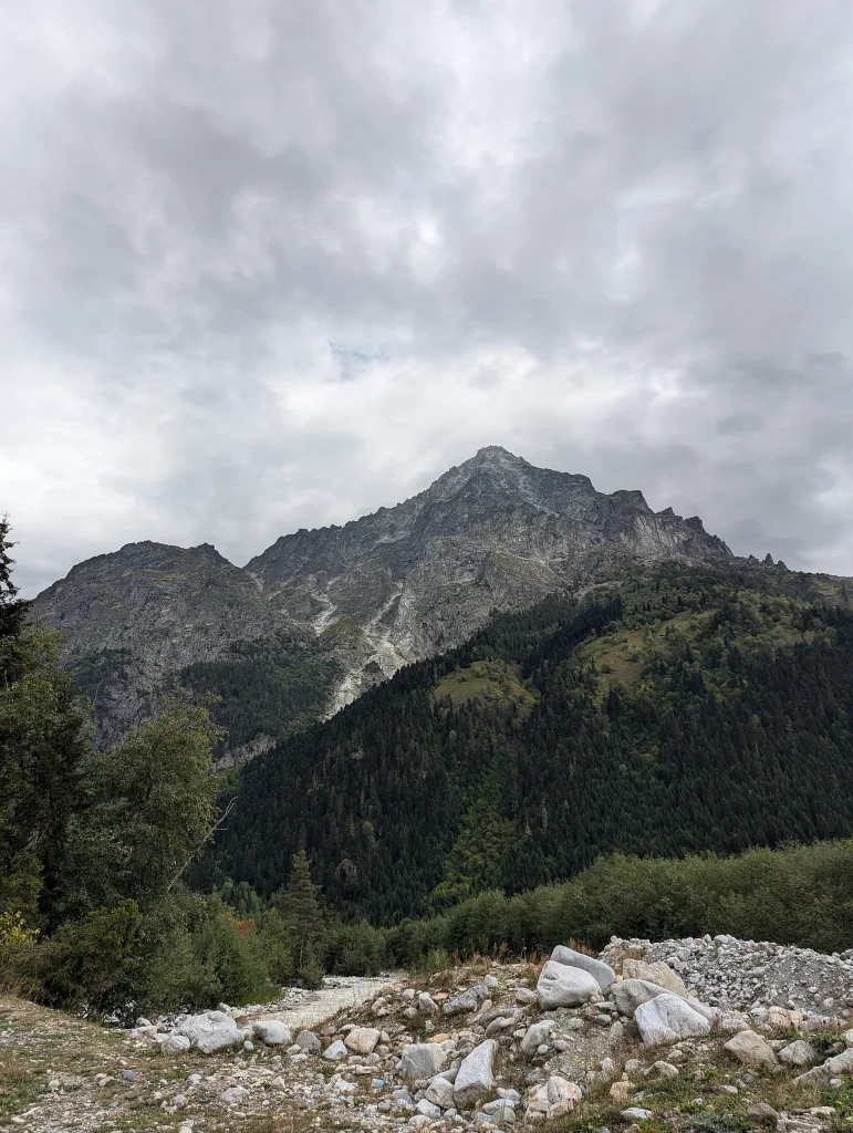 A rugged peak rises above forest and valley along the Svaneti trekking route near Mestia.