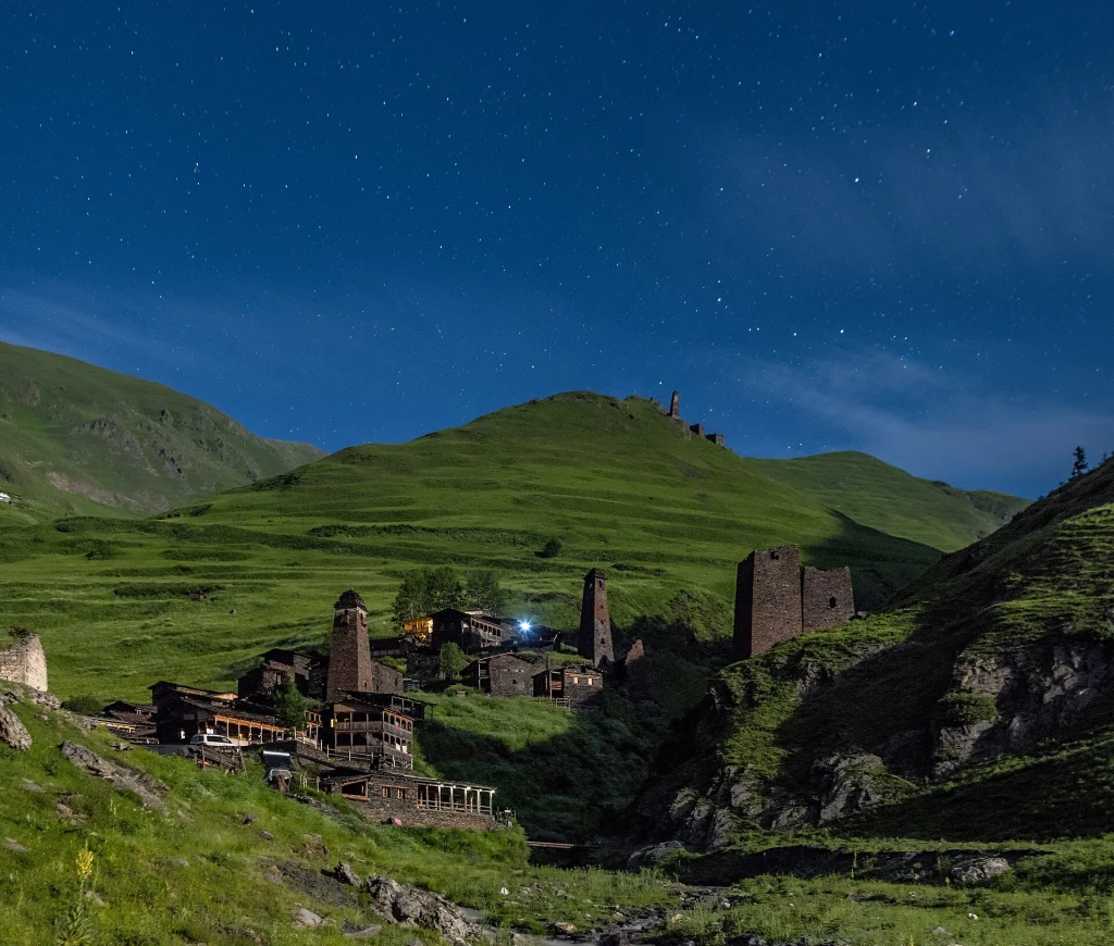 Dartlo village glows under a starry night sky in the mountains of Tusheti.