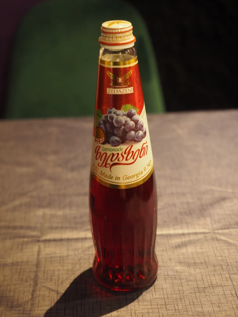 A bottle of Zedazeni grape lemonade, a traditional Georgian soft drink enjoyed alongside local beverages.