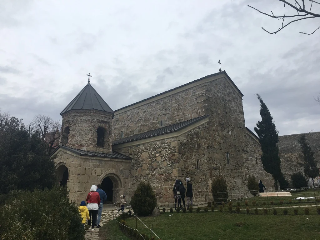 Visitors approach the ancient Zedazeni Monastery complex on its mountain site.