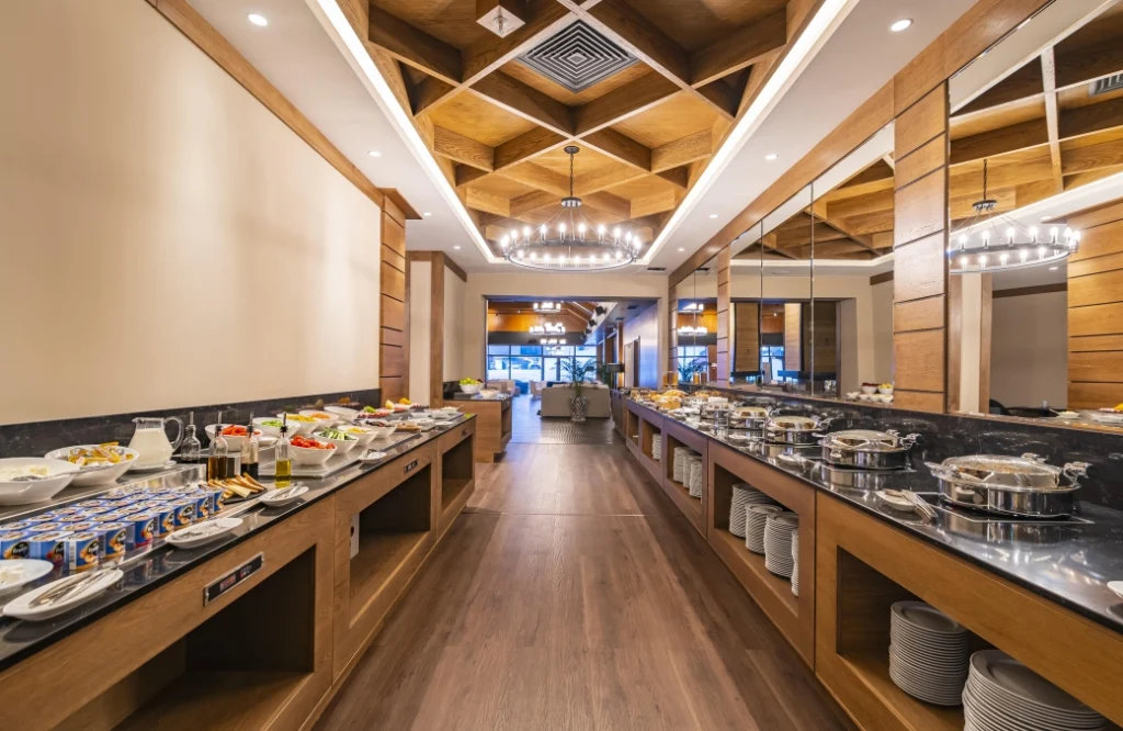 A la Carte Restaurant — Buffet dining area with mirrored serving stations and wooden ceiling design.