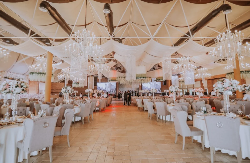 Banquet Hall — Elegant banquet hall interior set up with round tables, chandeliers, and draped ceiling.