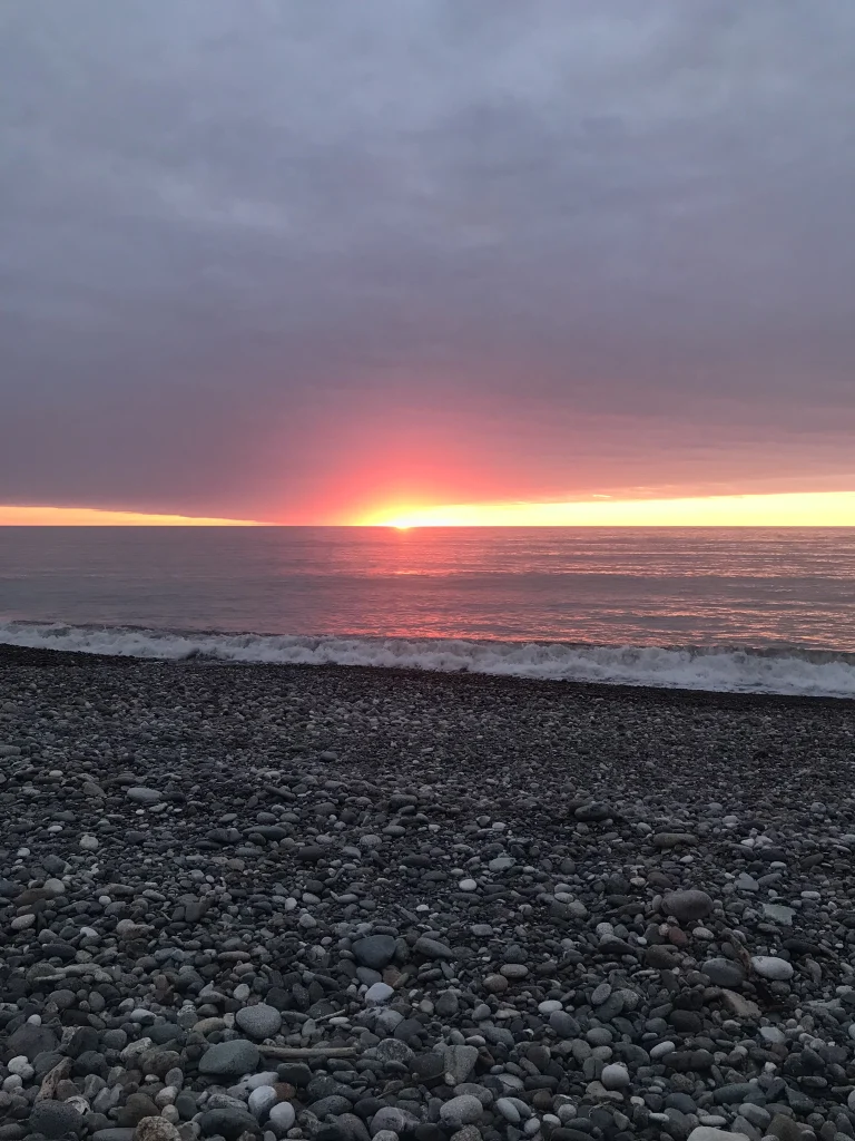Vivid sunset over the Black Sea seen from a pebble beach.