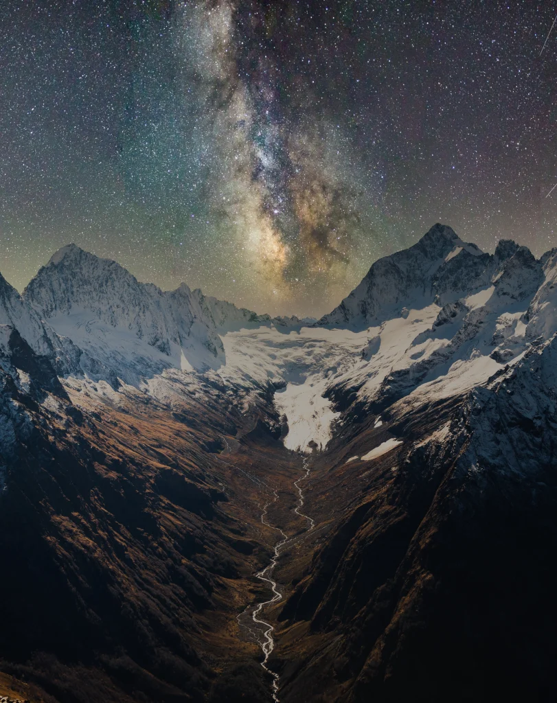 The Milky Way blazes over snow-capped Caucasus peaks, the kind of dark sky Georgia offers.