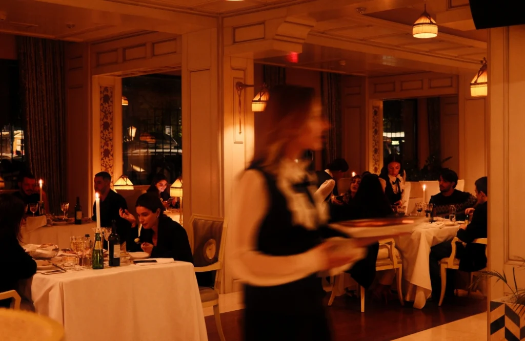 Daira Restuarant — Elegant dining room with candlelit tables and staff serving guests in the evening.