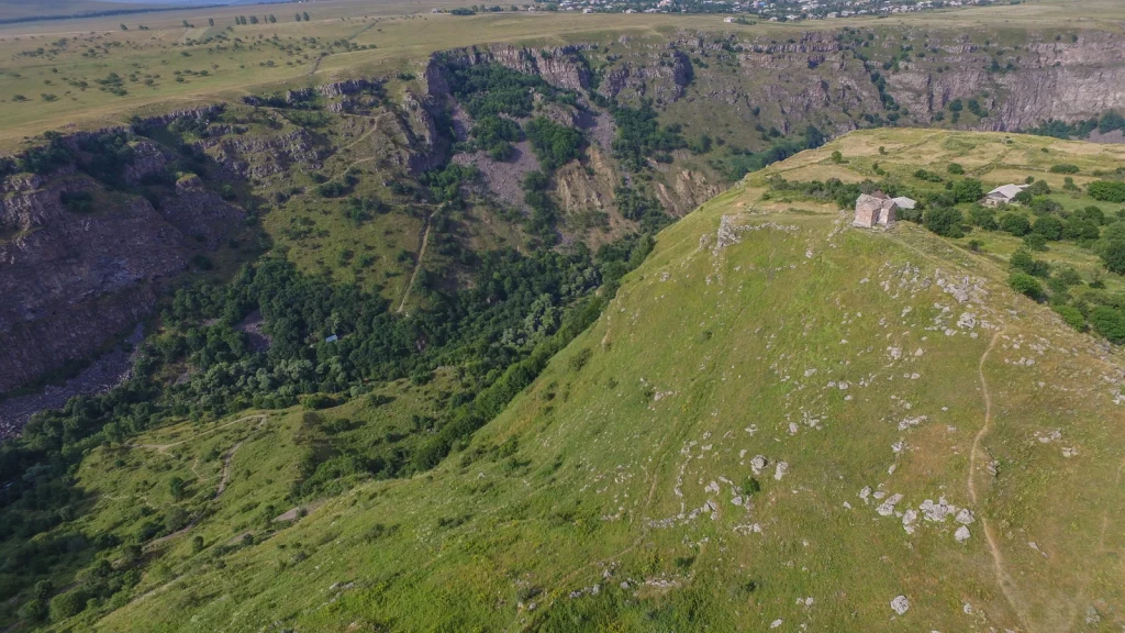 Aerial view of Dashbashi Canyon showing the deep gorge and the Birtvisi fortress ruins on the ridge.