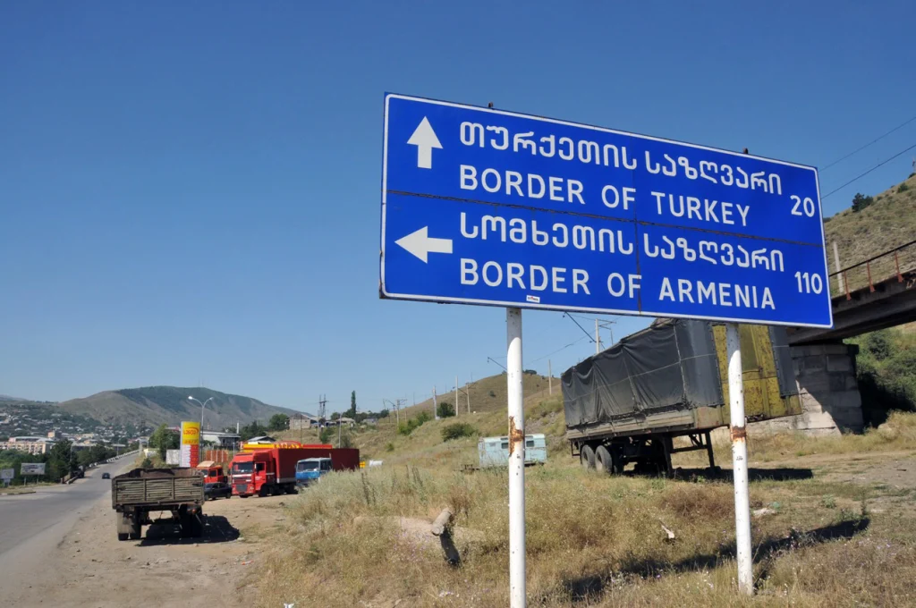 A road sign near Tbilisi points toward the borders of Turkey and Armenia, marking Georgia's crossroads location.