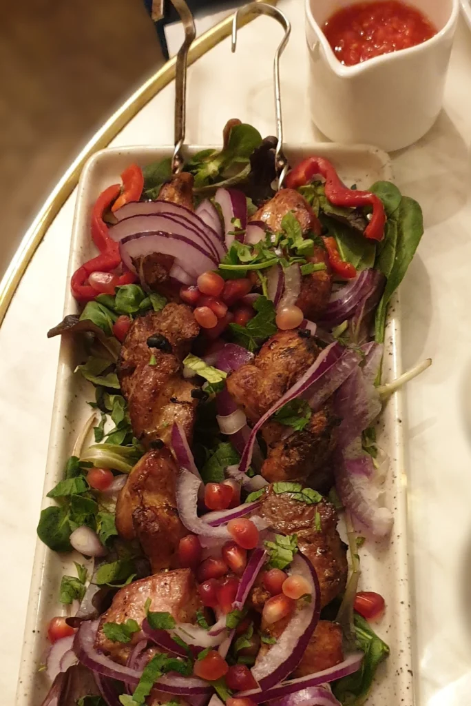 Traditional Georgian grilled meat skewers with pomegranate seeds, a dish Argentine travelers will recognize and enjoy.