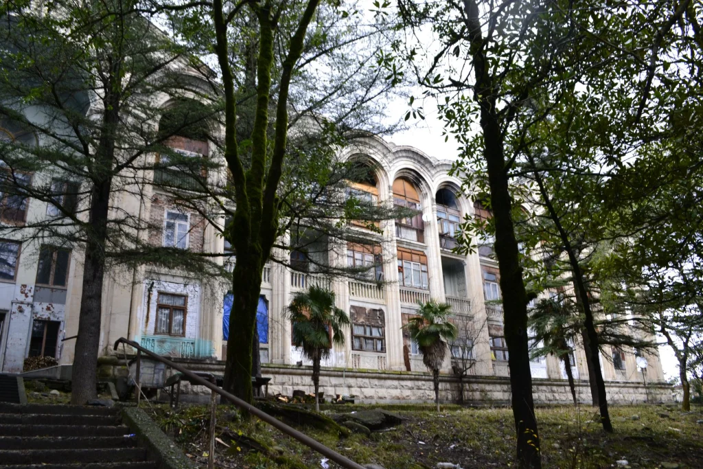 The abandoned Gelati sanatorium in Tskaltubo, overgrown with trees and vines.