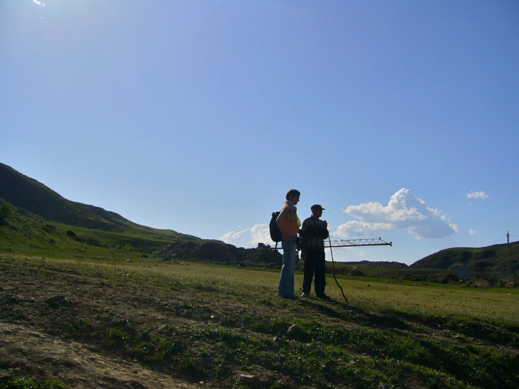 Rural countryside in Georgia with rolling green hills under a clear sky.