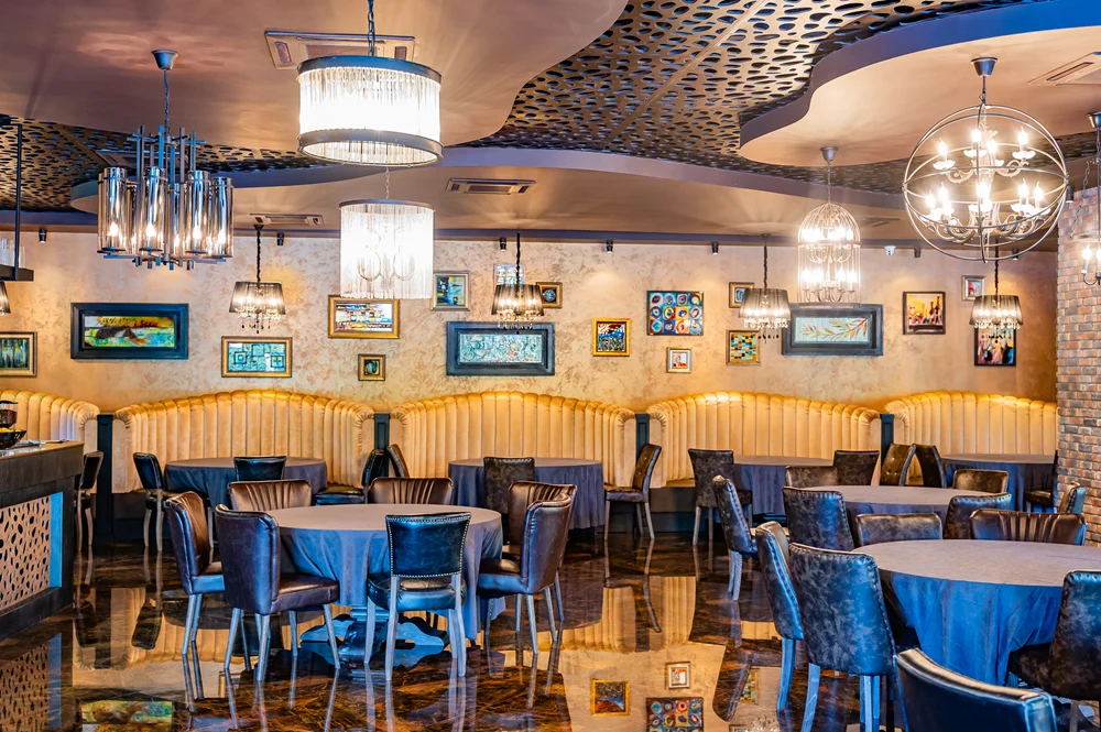 Georgian Restaurant — Elegant restaurant interior with patterned ceiling, chandeliers, and framed art on walls.