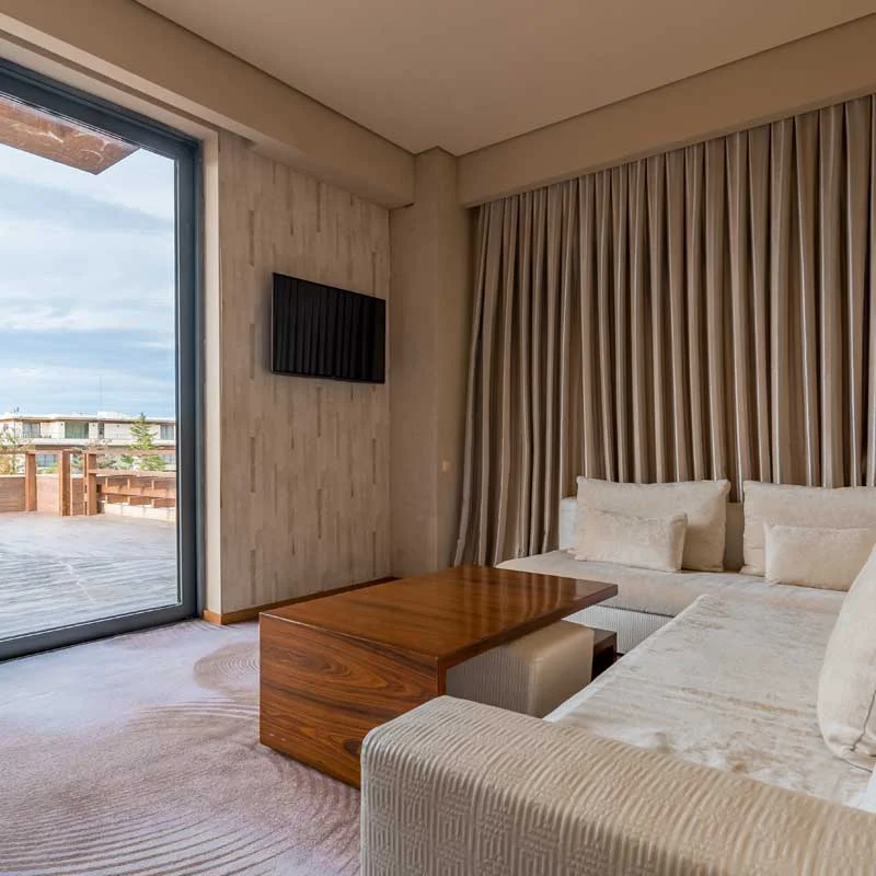 Georgian Restaurant — Hotel suite with lounge seating and large window opening to a private terrace.