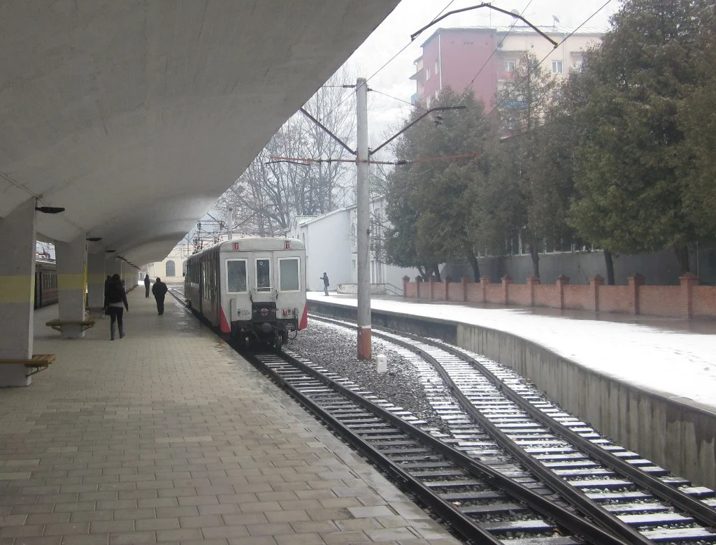 Passengers walk along the platform beside the Kukushka train at Borjomi station.