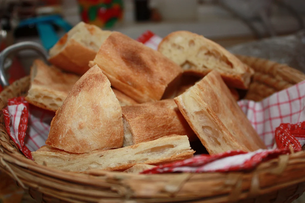 A basket of freshly baked Georgian flatbread pieces served on a table.