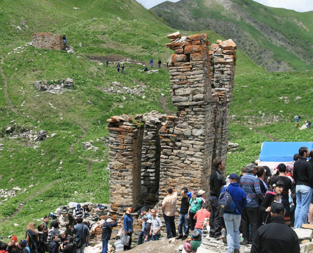 Worshippers climb past ancient stone ruins near Lomisa church during the pilgrimage.
