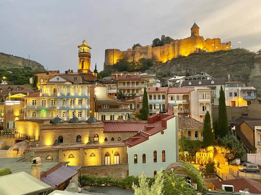 Narikala Fortress glows above Tbilisi's Abanotubani district at dusk, the heart of the capital.