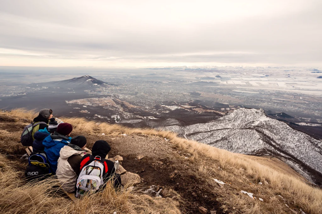 Hikers overlook the Caucasus mountains, illustrating trekking areas where tick-borne encephalitis risk exists in Georgia.