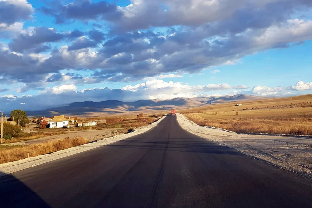 An open highway winding through Georgia's mountainous countryside, suited for a day-long minibus tour.