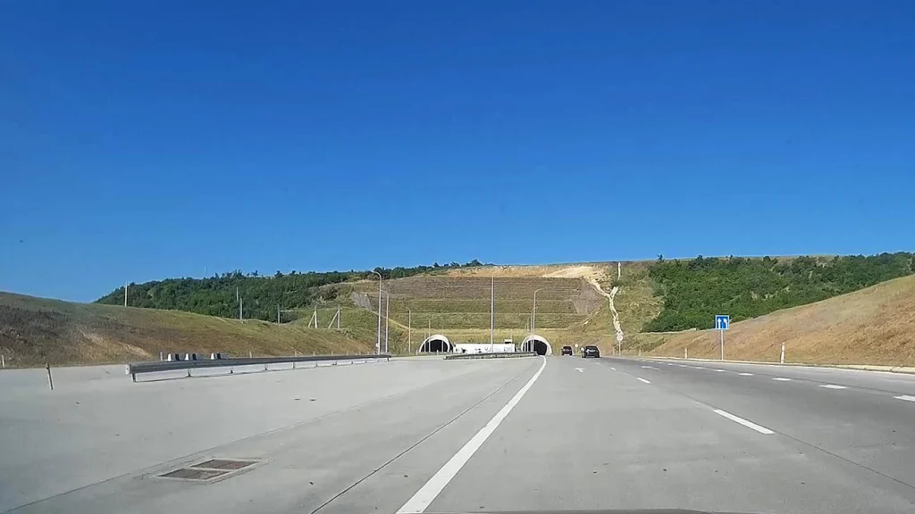 The Gori Tunnel entrance on Georgia's East-West Highway under a clear blue sky.