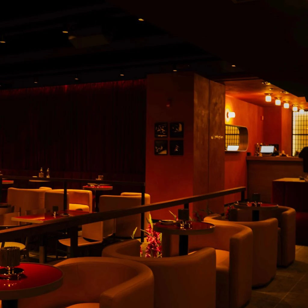 Tatuza Jazz Club — Lounge area with curved cream armchairs and low tables near the bar.