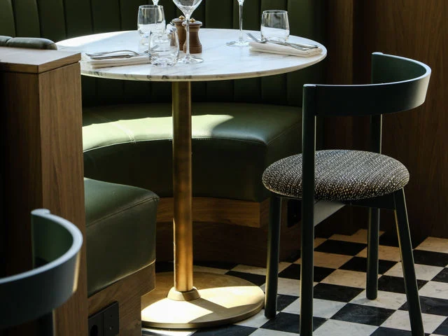 Telegraph Hotel — Elegant restaurant table set with glassware on a checkered marble floor.