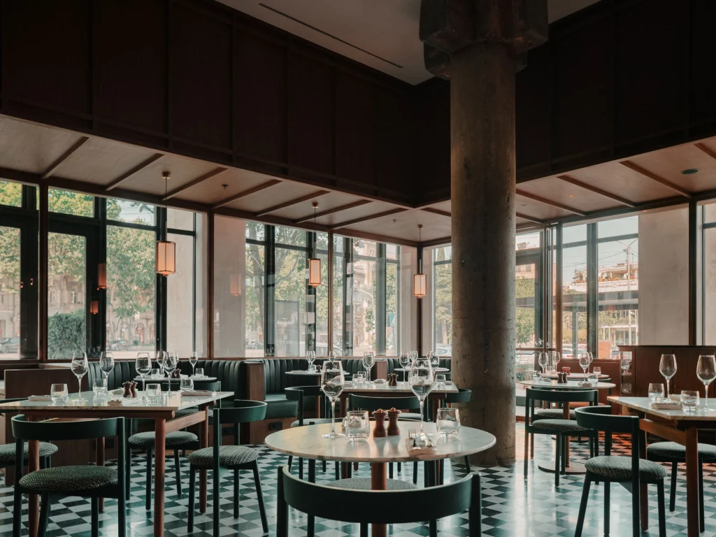 The Grill — Restaurant dining area with checkered floor, green chairs, and large windows.