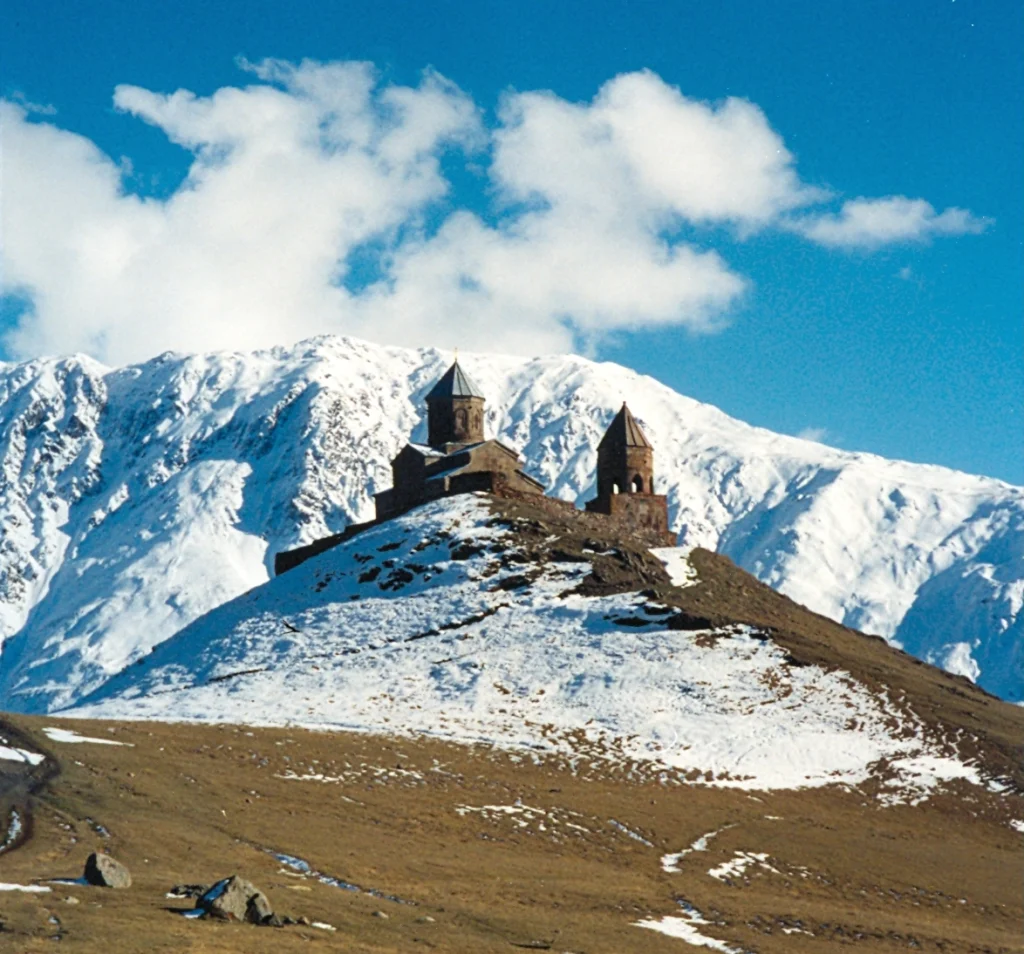 Gergeti Trinity Church beneath snow-capped Mount Kazbek, a classic early-spring day trip from Tbilisi.