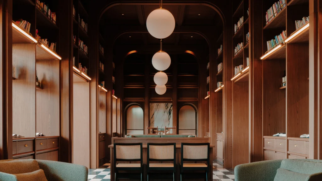 Wine Library — арочный лаунж, отделанный деревом, со встроенными книжными полками, плетёными стульями и подвесными светильниками-шарами.