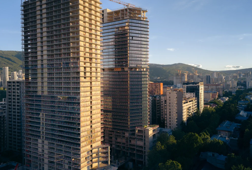 Planet Hollywood Hotel & Casino Tbilisi — Close aerial view of the tower facades overlooking surrounding Tbilisi cityscape and green hills.